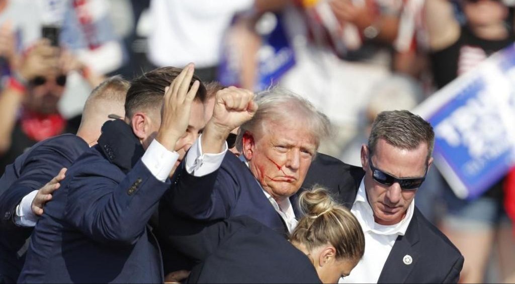 Video shows Donald Trump, the leading Republican presidential contender, drop to the ground and then stand up with blood on the side of his face – VIDEWO